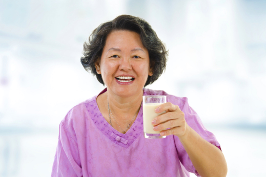 image of senior woman holding a glass of milk